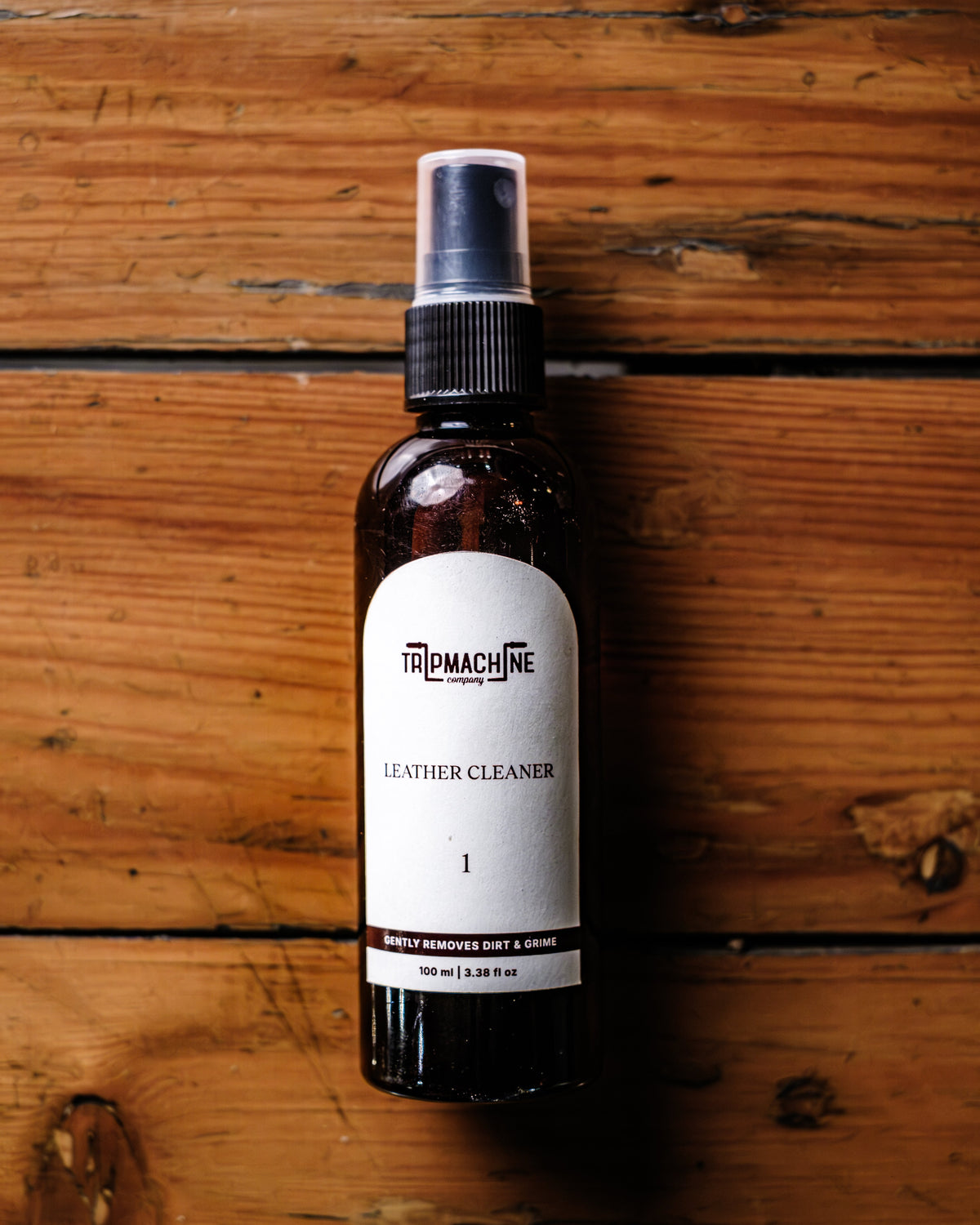 Bottle of leather cleaner on a wooden surface