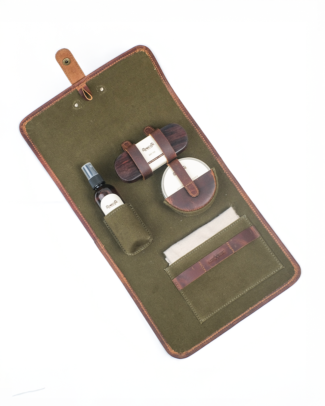 Leather care kit with a cleaner, conditioner, brush, and other items on an green roll-up case.